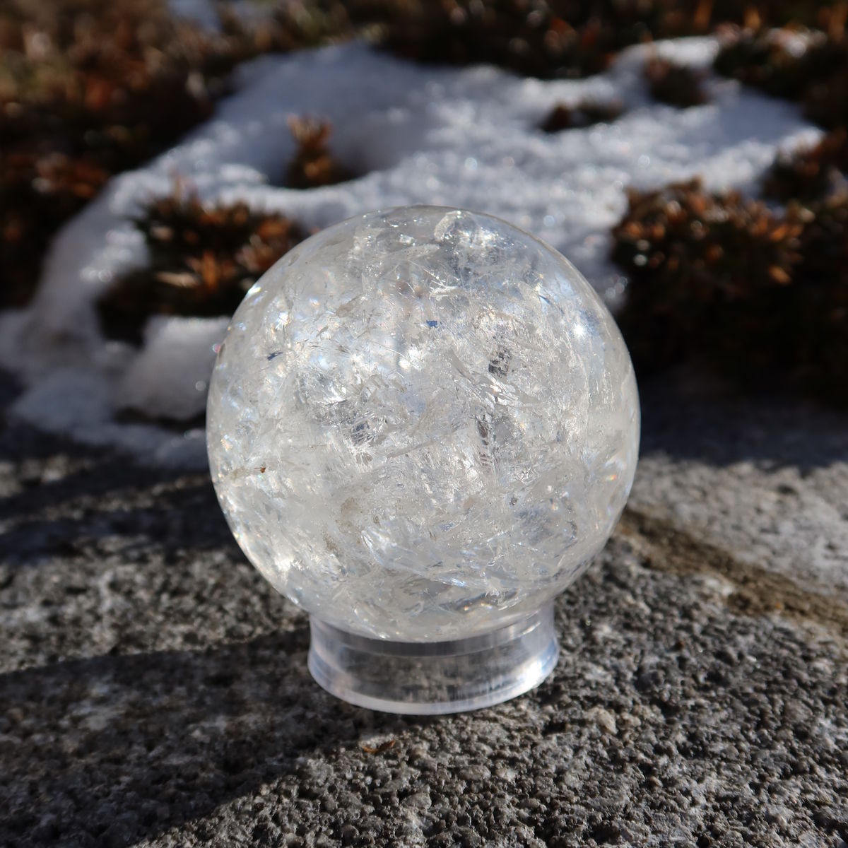 Bergkristall Kugel – Natürliche Kristallkugel 55mm Durchmesser Nr. 44 auf Stein im Freien