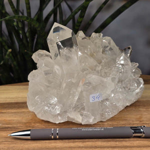 Bergkristall Stufe 1A Qualität, 10x14x9 cm - Klarheit und Fokus - UNIKAT Nr. 34, Rohkristall mit klaren Spitzen auf Holzoberfläche.