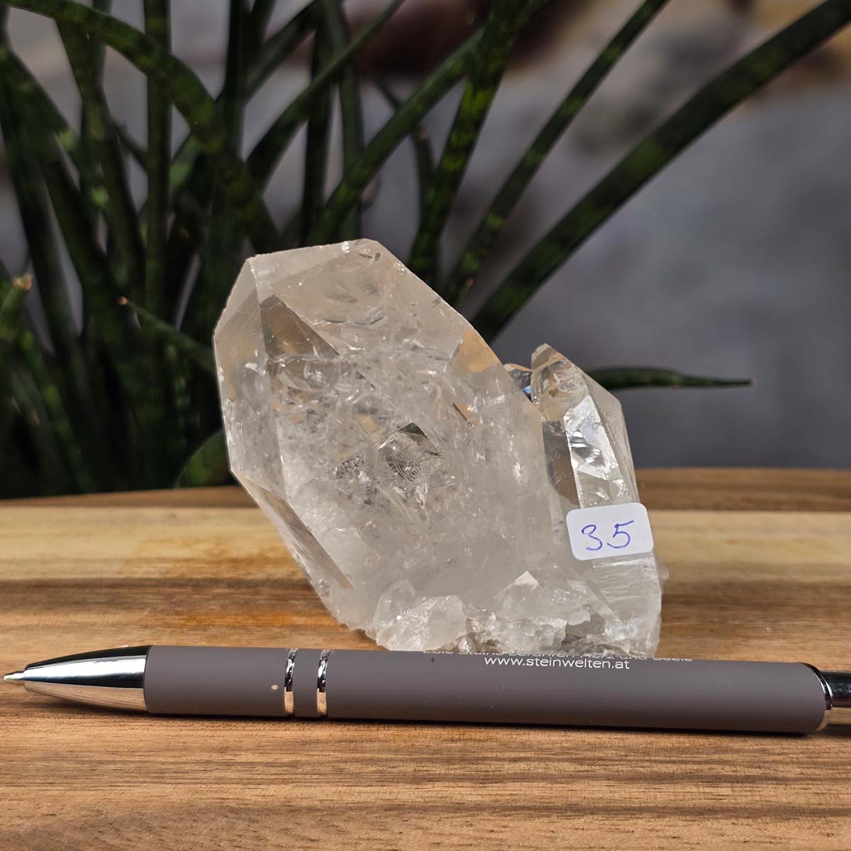 Bergkristall Stufe 1A Qualität, 7x8x5 cm - Klarheit und Fokus - UNIKAT Nr. 35 aus Brasilien, roher Kristall mit klaren Spitzen auf Holztisch mit Stift.