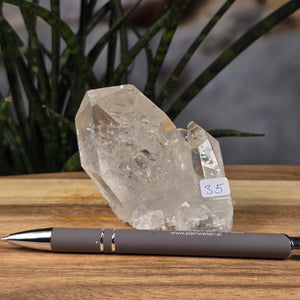Bergkristall Stufe 1A Qualität, 7x8x5 cm - Klarheit und Fokus - UNIKAT Nr. 35 aus Brasilien, roher Kristall mit klaren Spitzen auf Holztisch mit Stift.