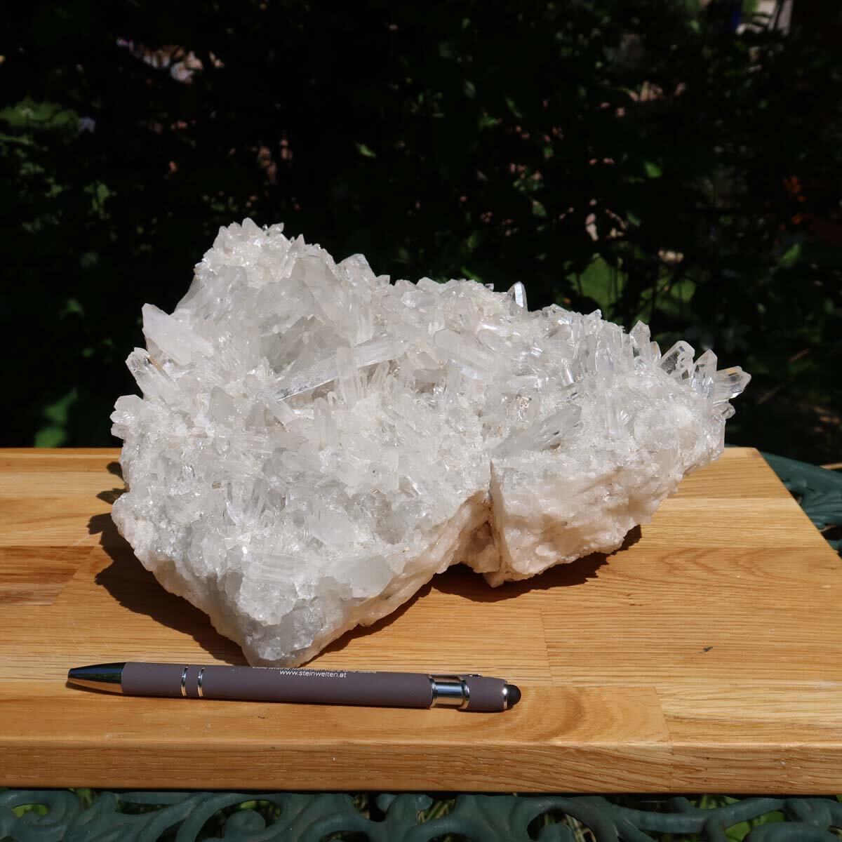 Raw Bergkristall crystal cluster on a wooden board with pen, showcasing clarity and natural beauty, weighing 5.2kg, UNIKAT Nr. 17.