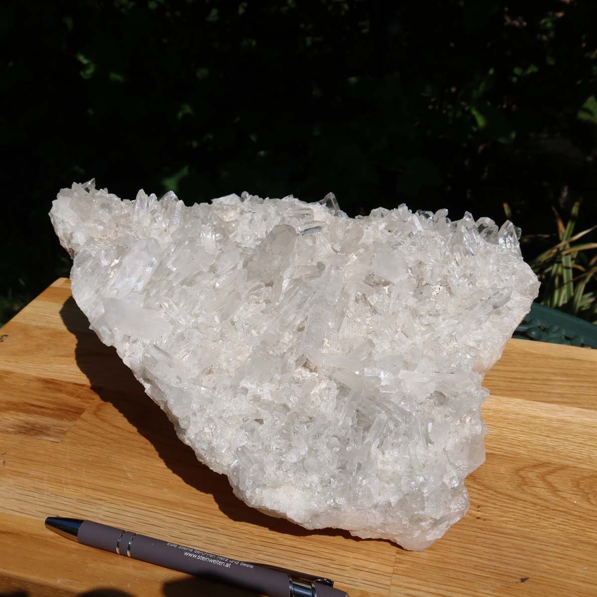 Raw Bergkristall crystal cluster on a wooden board with pen, showcasing clarity and natural beauty, weighing 5.2kg, UNIKAT Nr. 17.