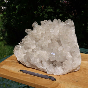 Raw Brazilian Bergkristall Stufe 1A, 5.9kg on wooden board, showcasing natural clarity and unique growth structure