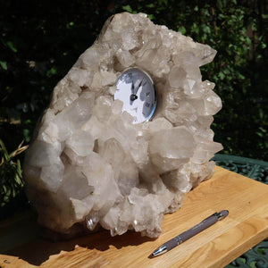 Bergkristall Stufe 1A mit Uhr, großen Spitzen, 12kg, naturbelassen, Sammlerstück aus Brasilien, auf Holztisch mit Stift im Freien.