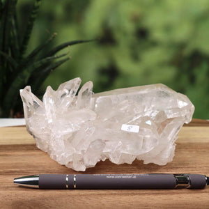Raw Brazilian Bergkristall crystal cluster, 0.8kg, showcasing natural clarity and unique formations with pen for scale.