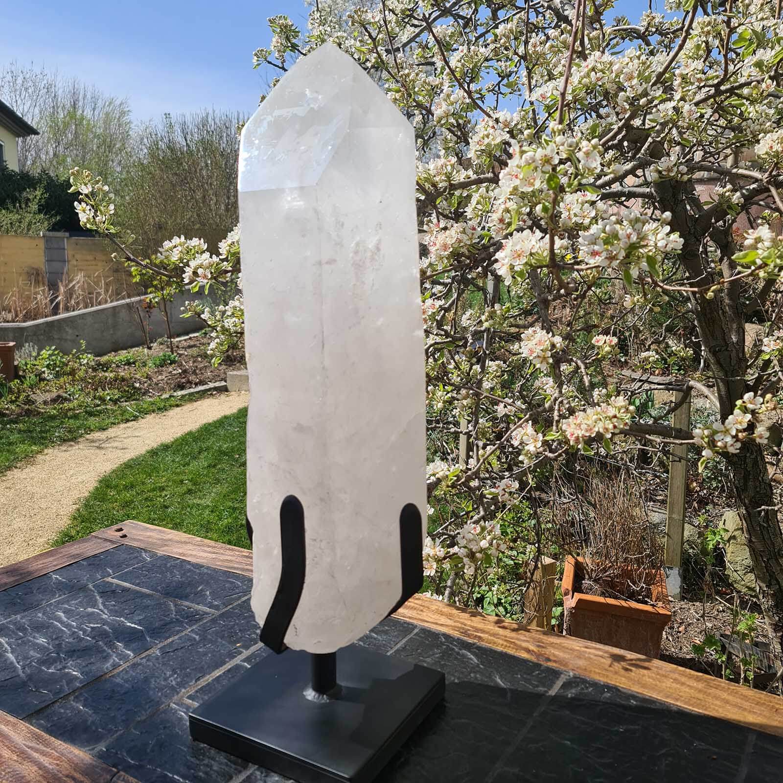 Bergkristall XXL Quarzspitze auf Metallständer im Garten, ideal für Meditationsräume und exklusive Wohnbereiche.