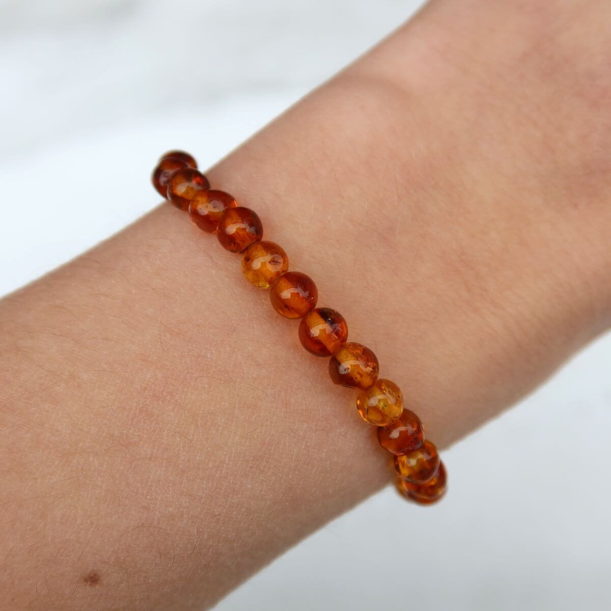 Honigfarbenes Bernstein Armband aus baltischem Bernstein, edel und leicht, präsentiert auf einem Handgelenk, ideal für besondere Anlässe.