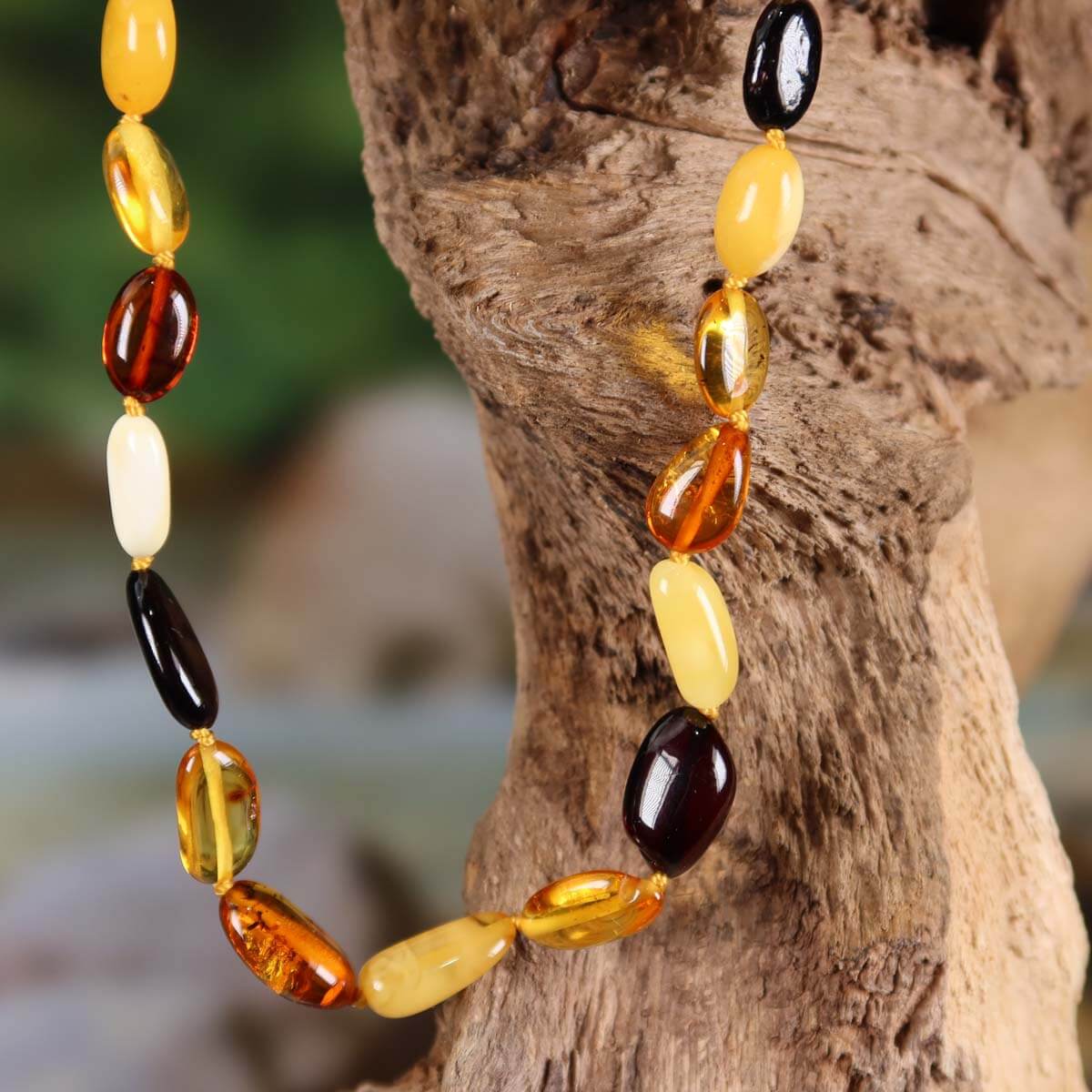 Elegant Bernstein Edelsteinkette 45cm mit goldenen Perlen, ideal für Selbstvertrauen und Leichtigkeit, präsentiert auf Holz