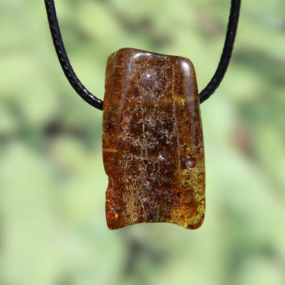 Natürlicher Bernstein Anhänger gebohrt, 32mm, einzigartiges Unikat Nr. 12, schimmernd bei Lichteinfall, symbolisiert Lebensfreude.