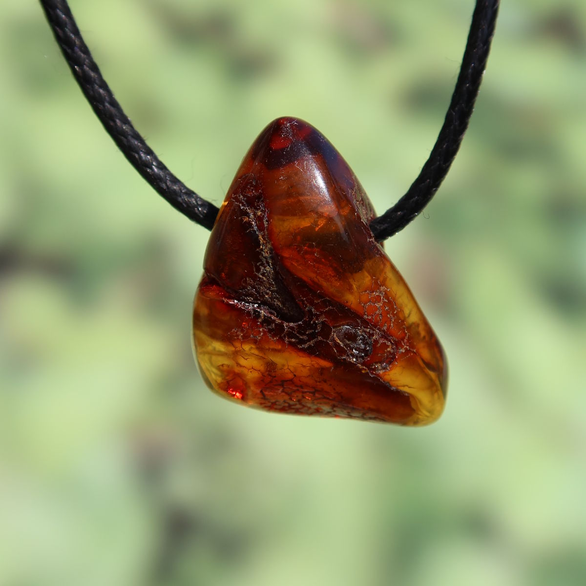Natural amber pendant, 29mm, unique piece No. 18, symbolizing joy and self-confidence with a warm, translucent glow.