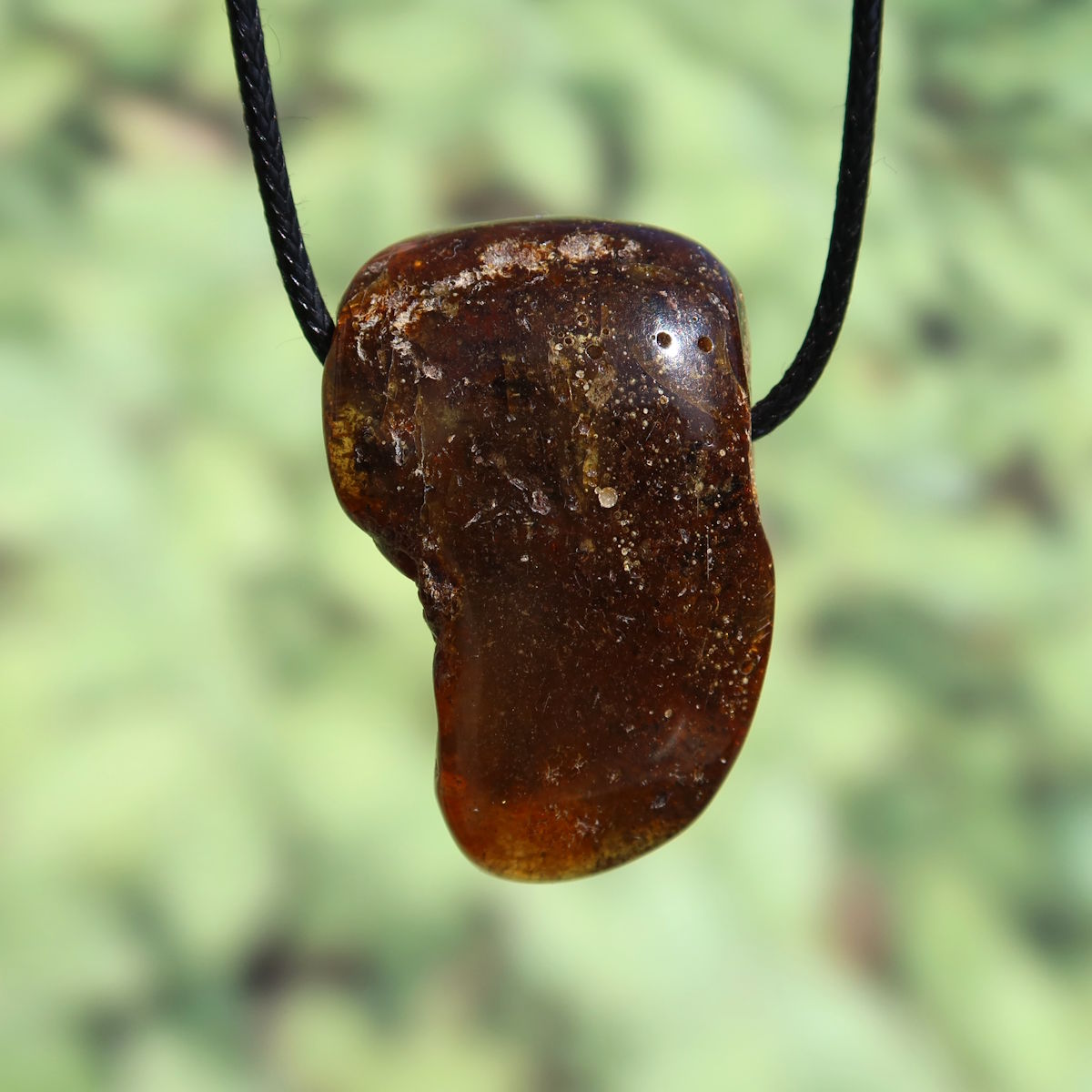 Natürlicher Bernstein Anhänger mit sanfter Transparenz, 46mm gebohrt, Unikat Nr. 7, schimmert schön im Licht, auf schwarzem Band.