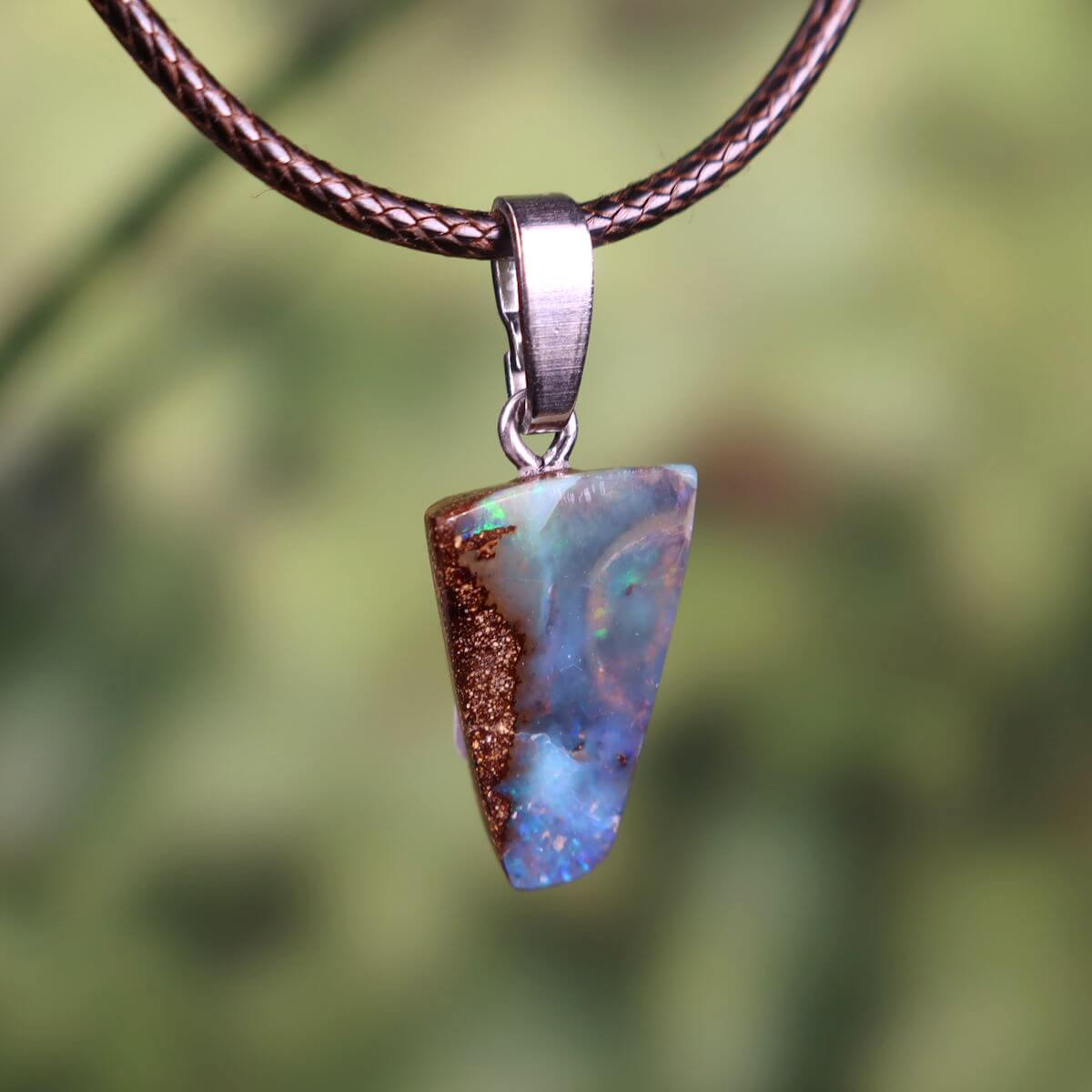 Handcrafted Boulder Opal pendant with sterling silver loop, size 20x12mm, displaying unique natural patterns and colors.