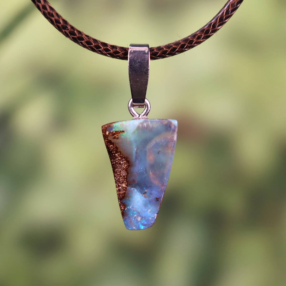 Handcrafted Boulder Opal pendant with sterling silver loop, size 20x12mm, displaying unique natural patterns and colors.