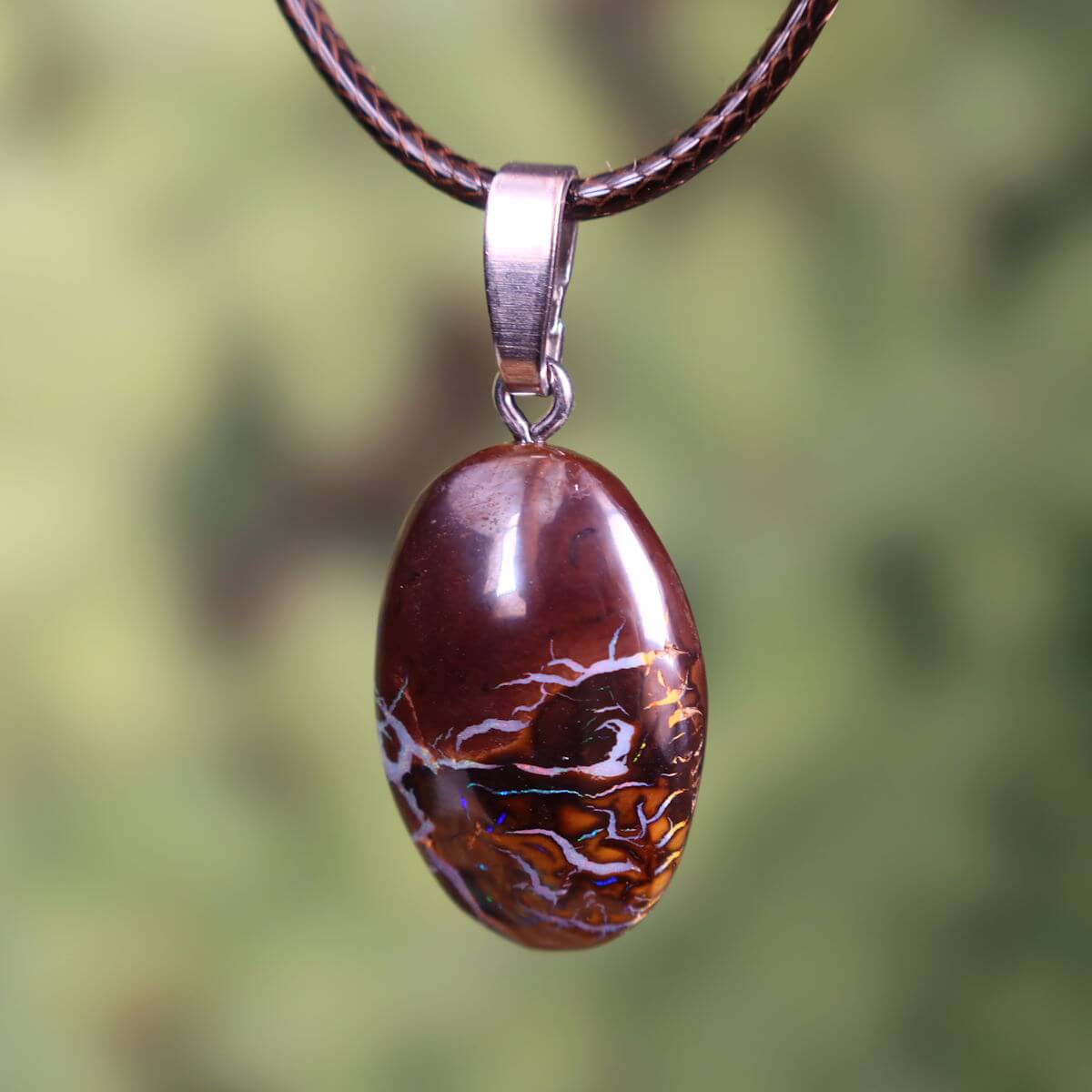 Boulder Opal pendant with silver loop on leather cord, unique gemstone from Australia.