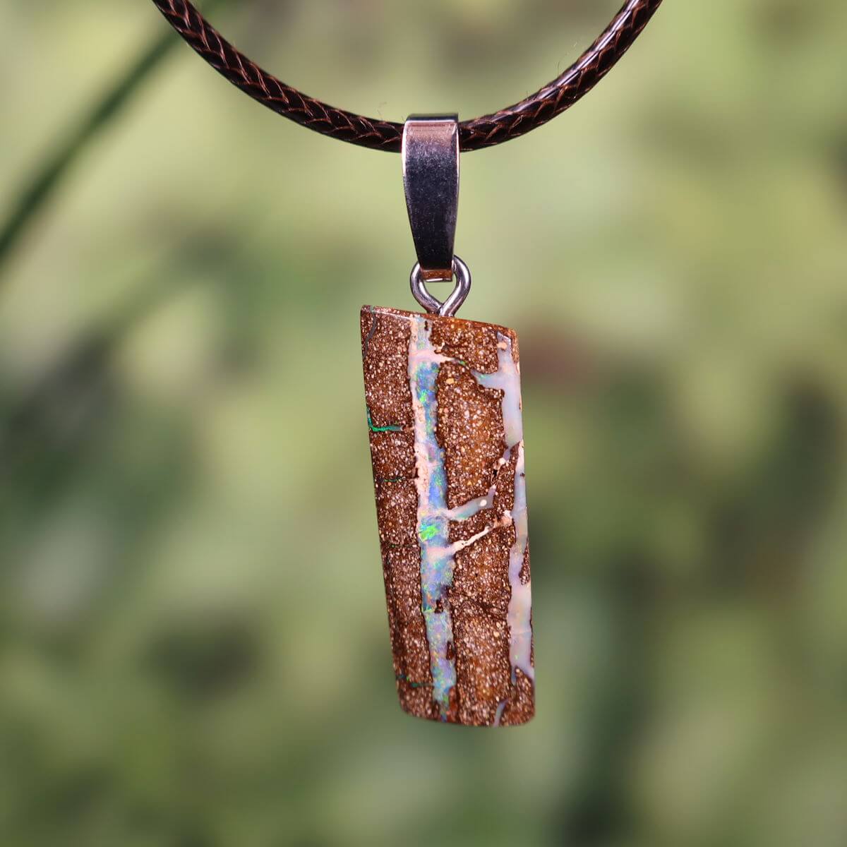 Boulder Opal pendant with silver loop, hand-polished, unique piece from Australia, 27x11mm, exemplifying natural beauty and elegance.