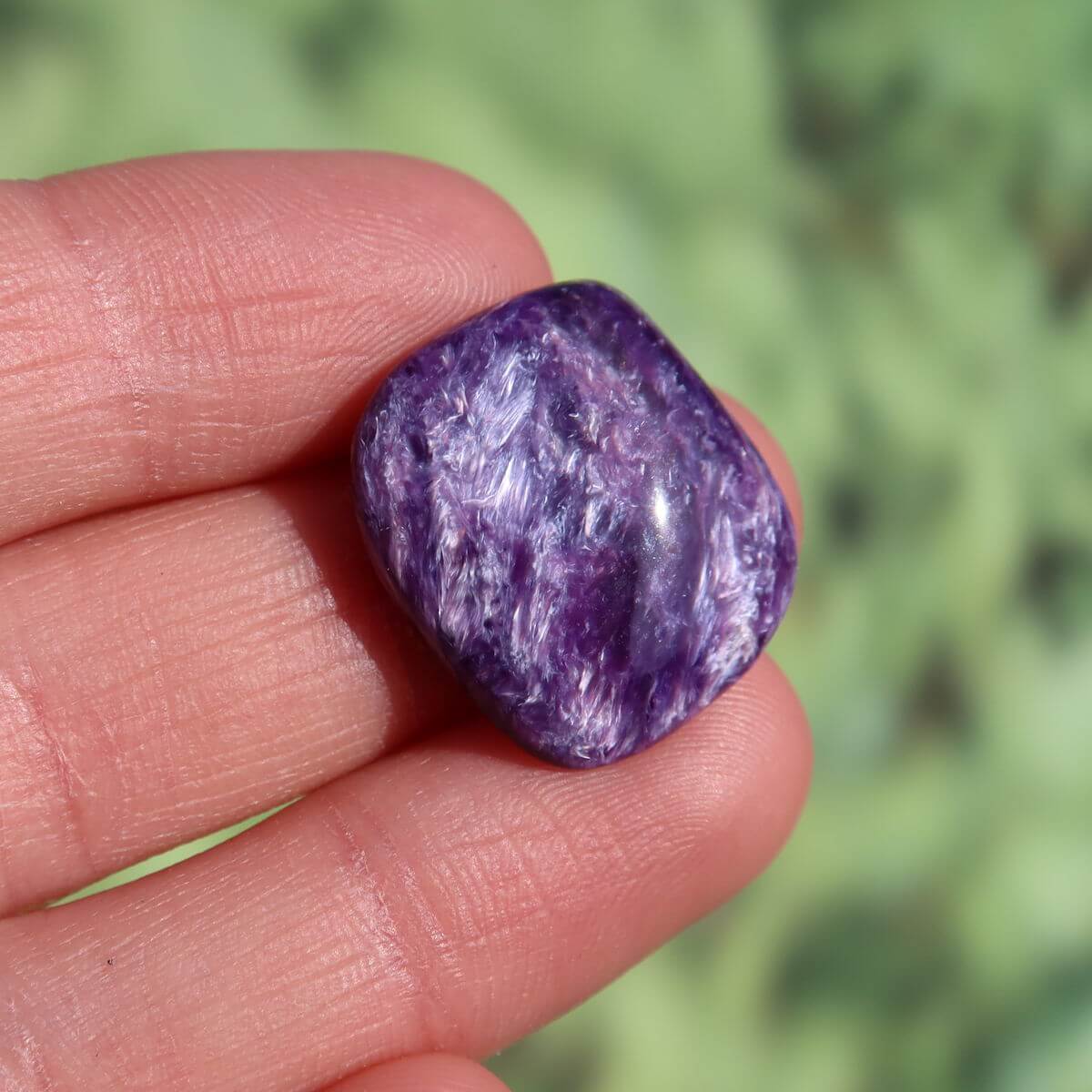 Violet Charoit Handschmeichler 20mm in hand, unique gemstone from Russia. Available for online purchase. Perfect for necklaces and collections.