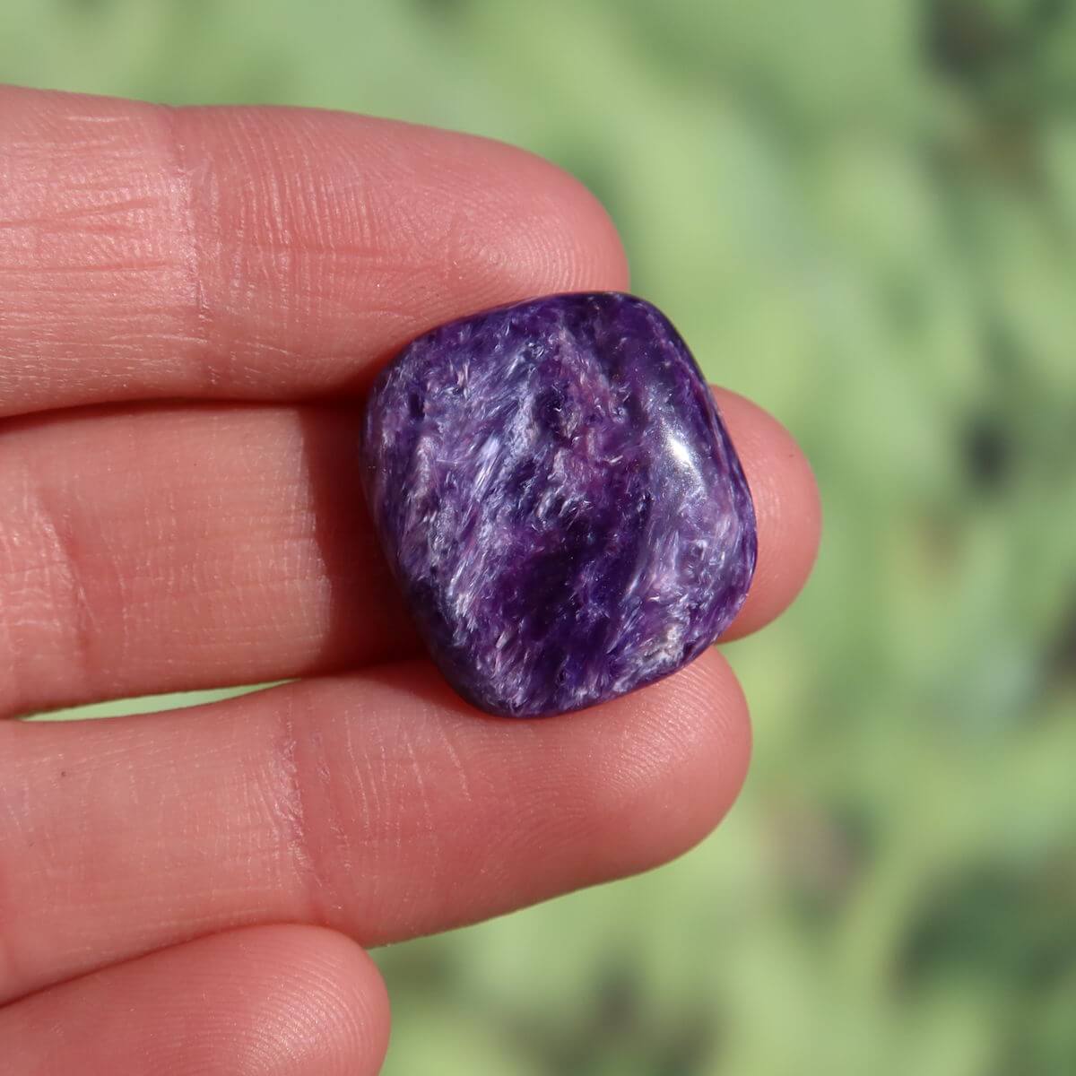 Violet Charoit Handschmeichler 20mm in hand, unique gemstone from Russia. Available for online purchase. Perfect for necklaces and collections.