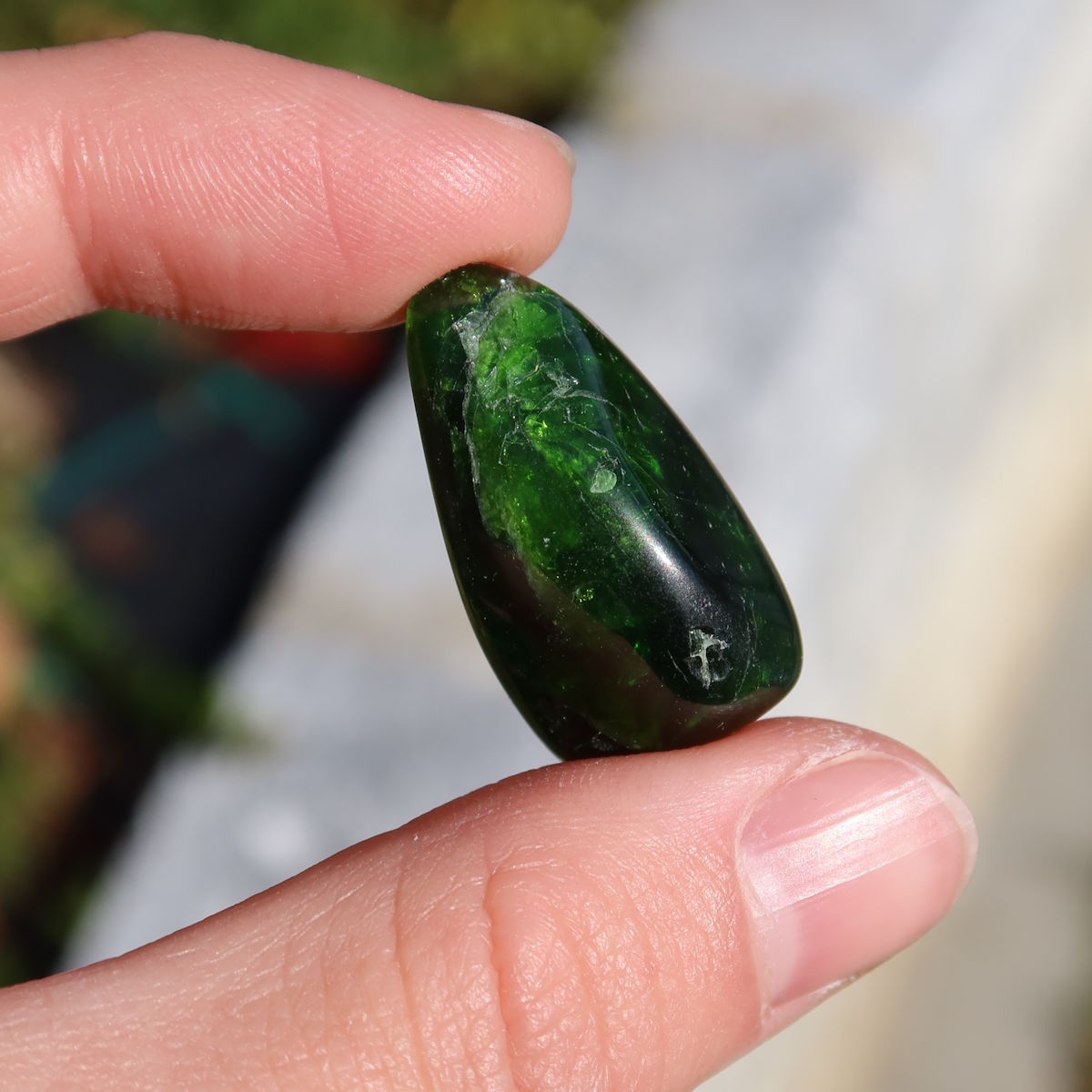 Person holding Natürlicher Chromdiopsid Handschmeichler 25mm - Kreativität und Leichtigkeit - UNIKAT Nr. 12, deep green stone.