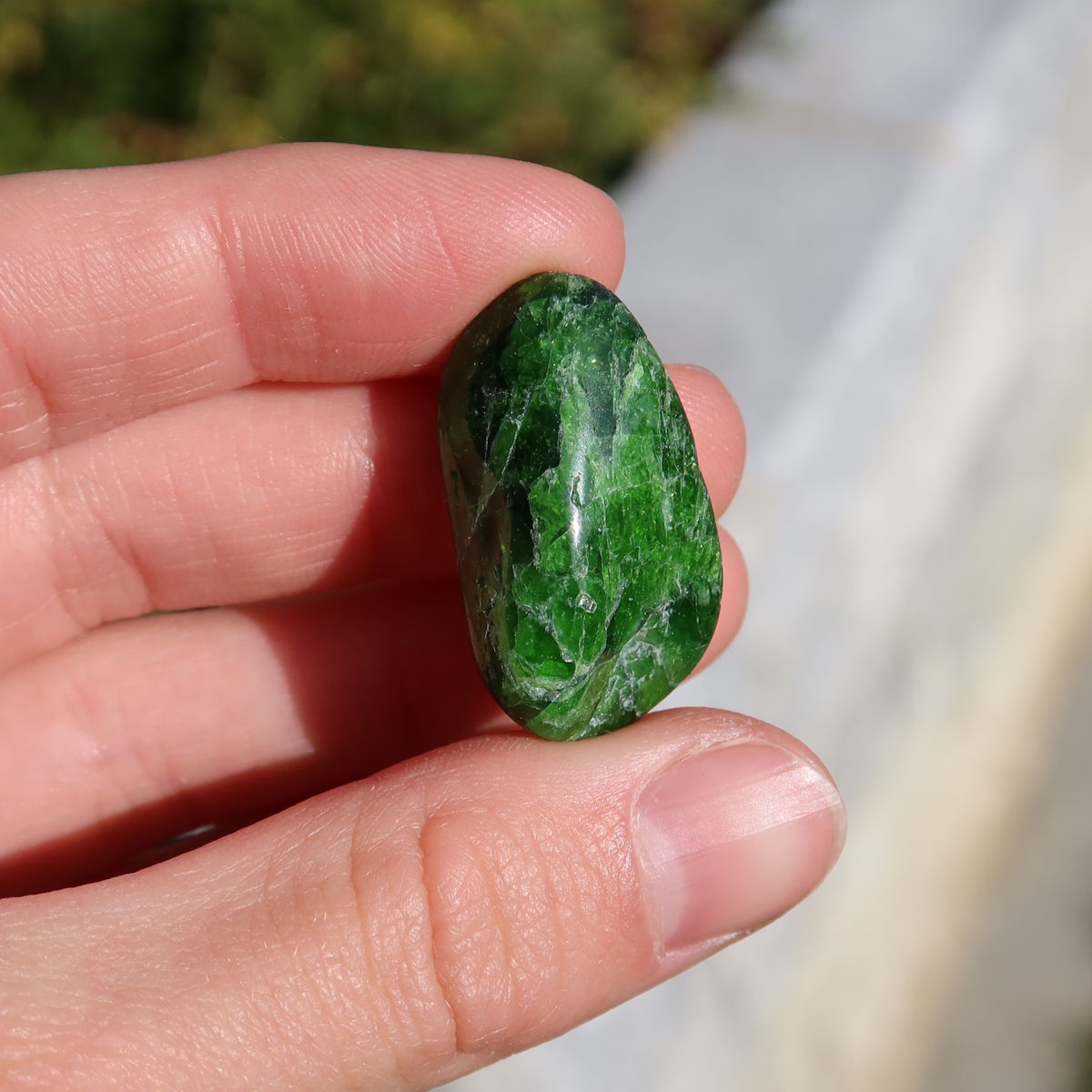 Natürlicher Chromdiopsid Handschmeichler 25mm - Kreativität und Leichtigkeit - UNIKAT Nr. 14; grüner Edelstein in Hand gehalten