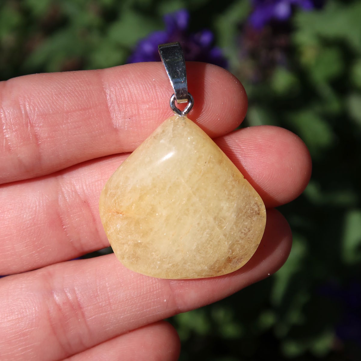 Yellow Danburit pendant 1A quality held in hand, unique gemstone with clear structure and vibrant energy.