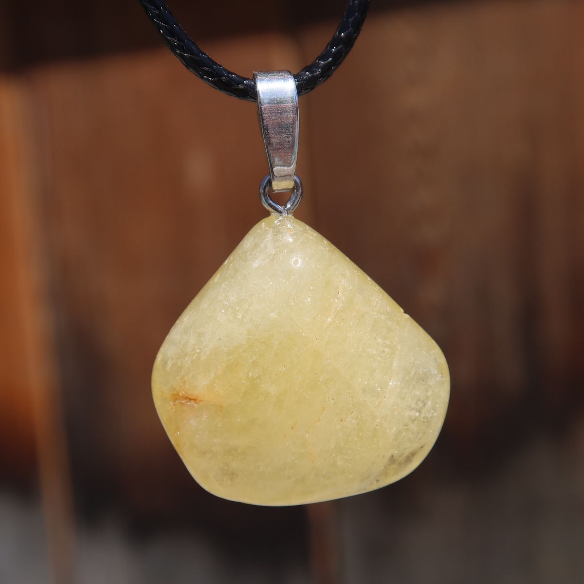 Yellow Danburit pendant 1A quality held in hand, unique gemstone with clear structure and vibrant energy.
