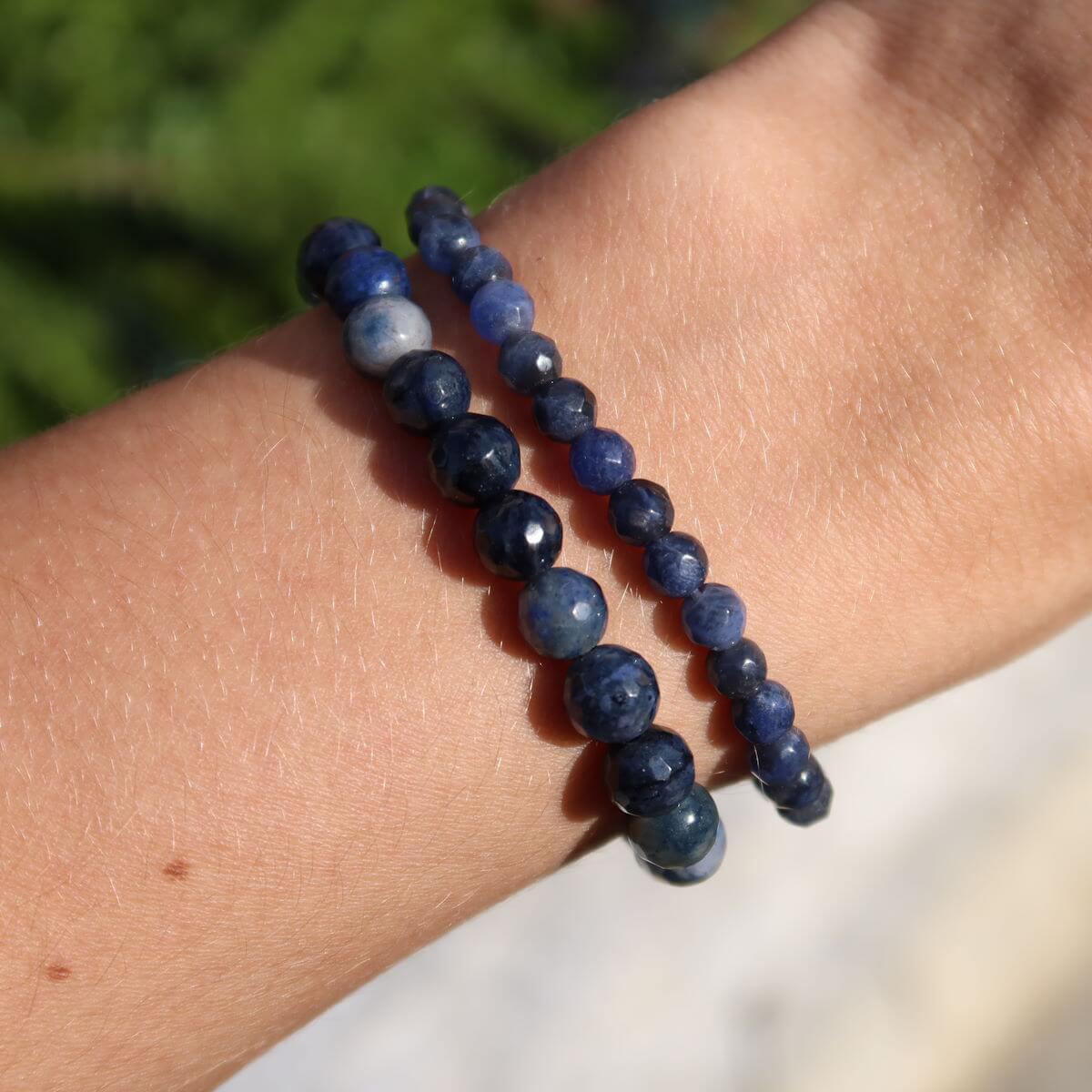Faceted Dumortierite gemstone bracelet in blue tones on wrist, 4-6-8mm beads, promotes calm and clarity, suitable for stress relief.