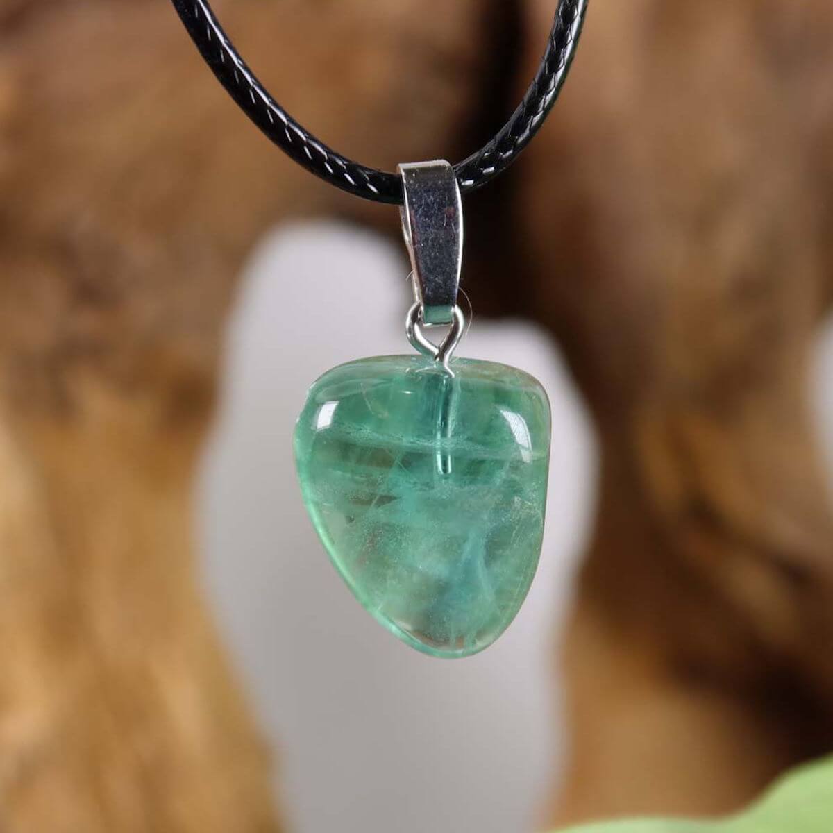 Fluorite pendant with unique green tones and silver rhodium-plated bail on leather cord, promoting concentration and freedom.