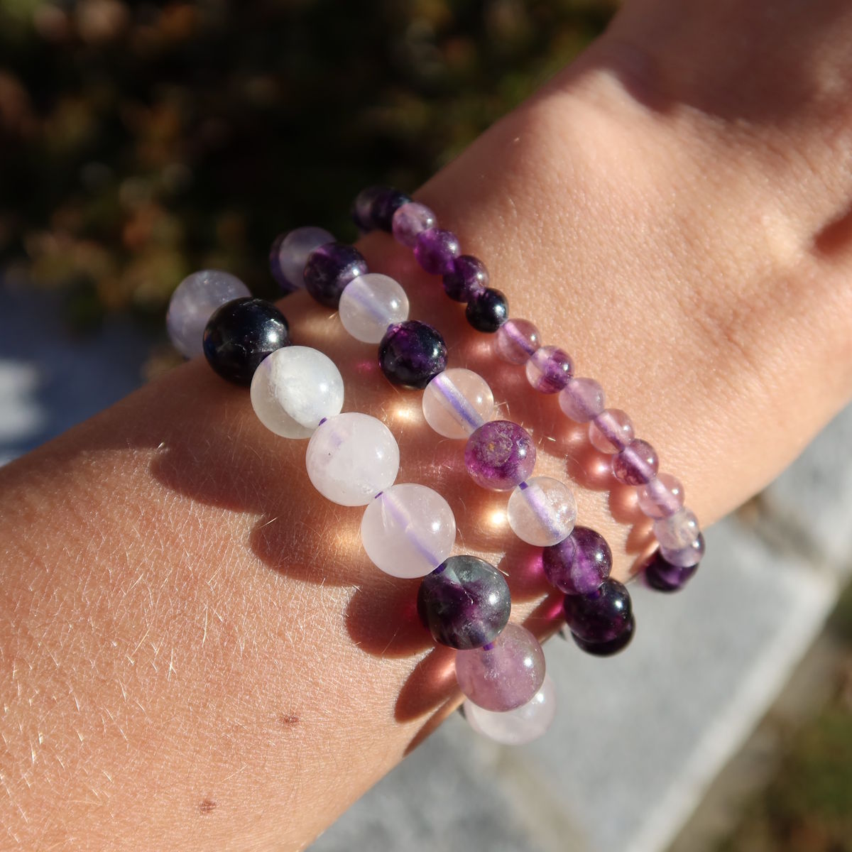 Fluorit lila - Edelstein Armband - 1 Stück - in Varianten 4-6-8 oder 10mm auf Handgelenk, zeigt violette und weiße Kugeln.