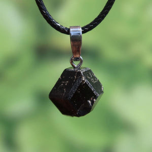 Natürlicher Granat Melanit Anhänger - Standfestigkeit und Stabilität - UNIKAT Nr. 2, eleganter schwarzer Edelstein auf grünem Hintergrund