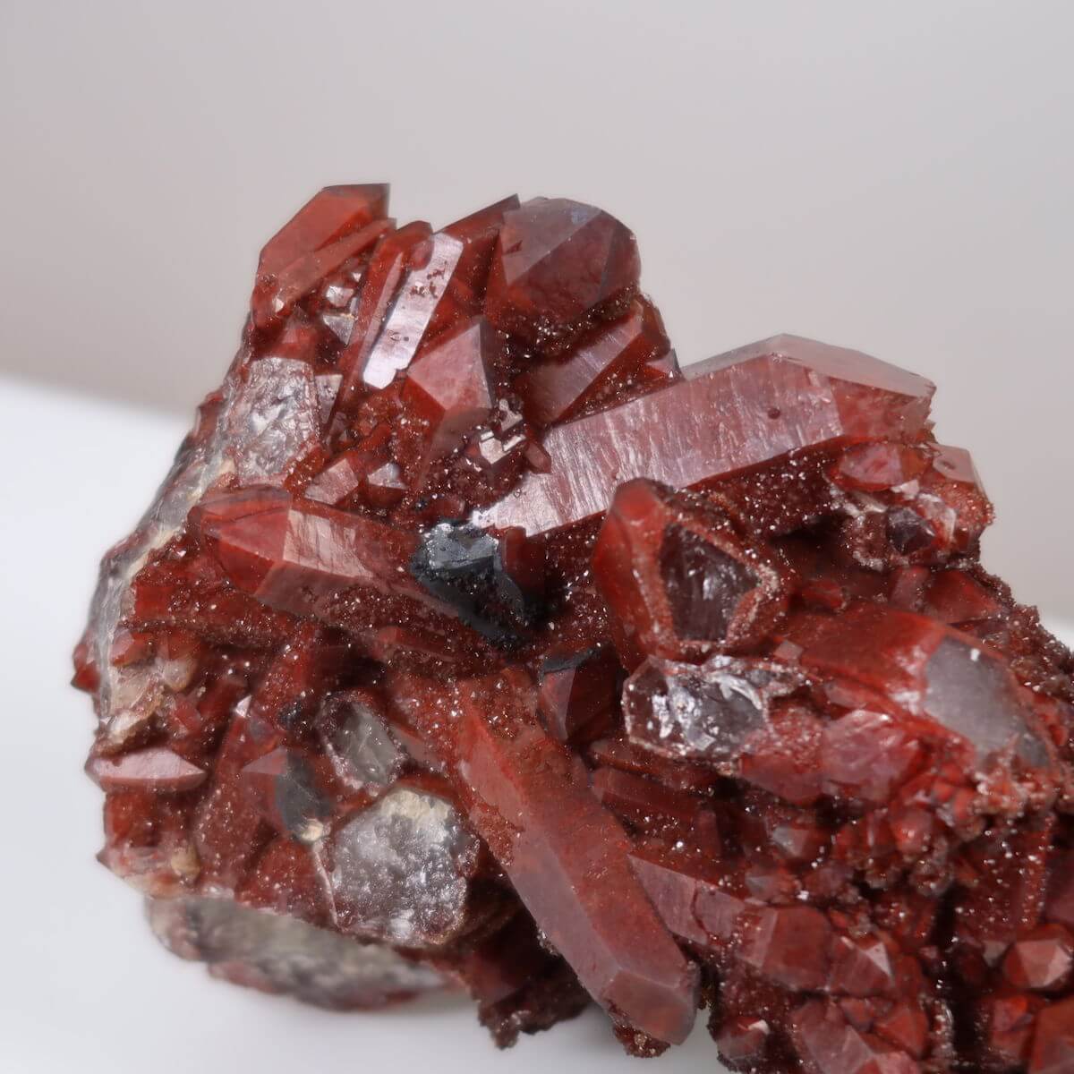 Seltene Hämatit Quarz Bergkristall aus Marokko neben einem Stift auf einem Tisch, Eisenquarz Sammlerstück, online kaufen bei Steinwelten.