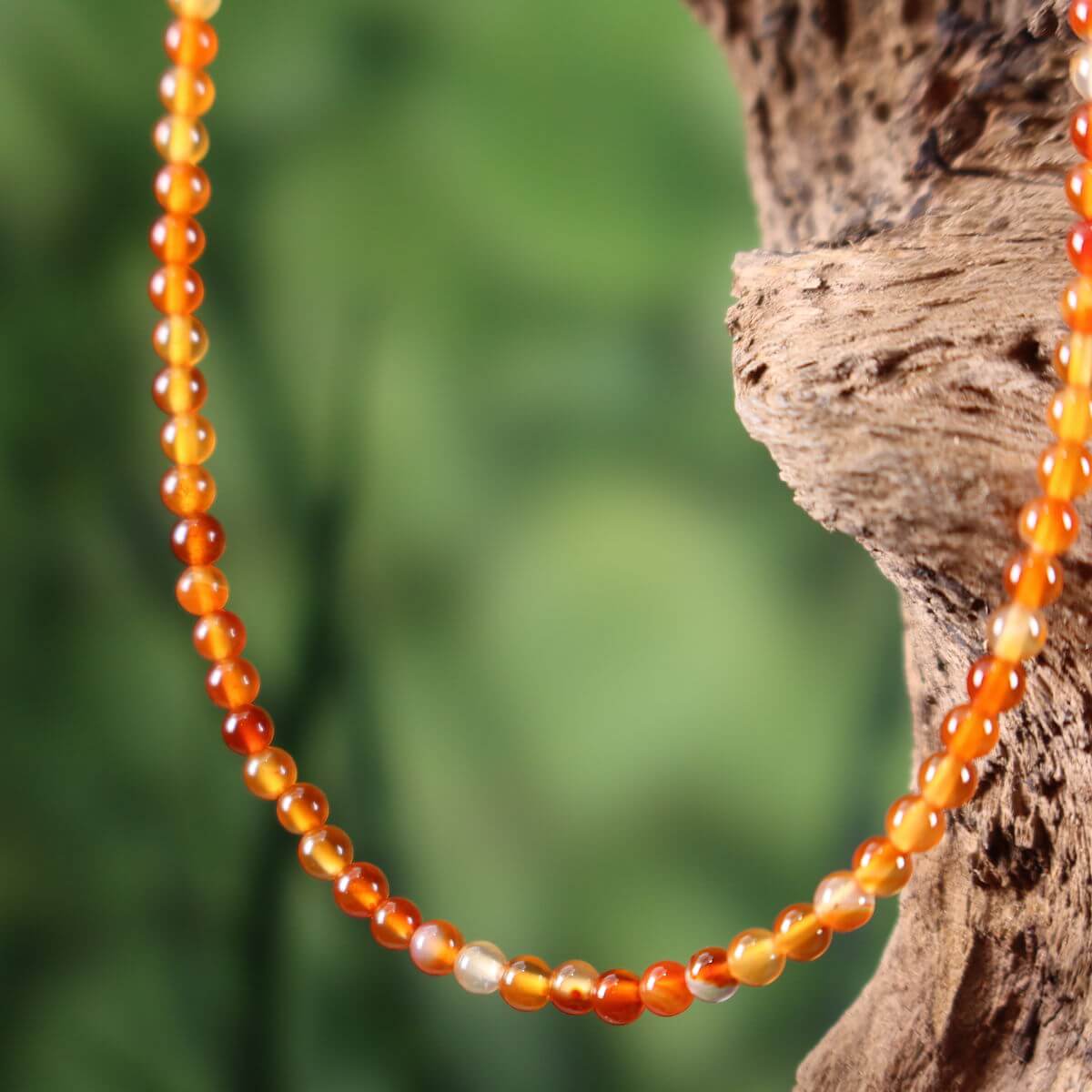Elegante Karneol Kette auf Holzdisplay, 41cm, hervorgehoben vor natürlichem Hintergrund. Perfekt für Selbstbewusstsein. Von Steinwelten.