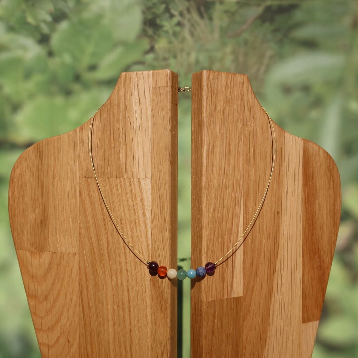Chakra Edelsteinkette 40cm aus sieben Chakren Edelsteinen auf einem Holzständer, ideal für Balance und Ausgeglichenheit.
