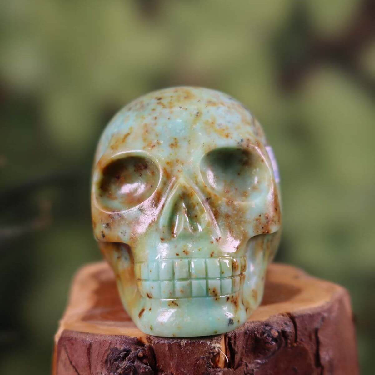 Handcrafted Andenopal crystal skull on wooden base, 6x6 cm, showcasing unique patterns and vibrant colors.