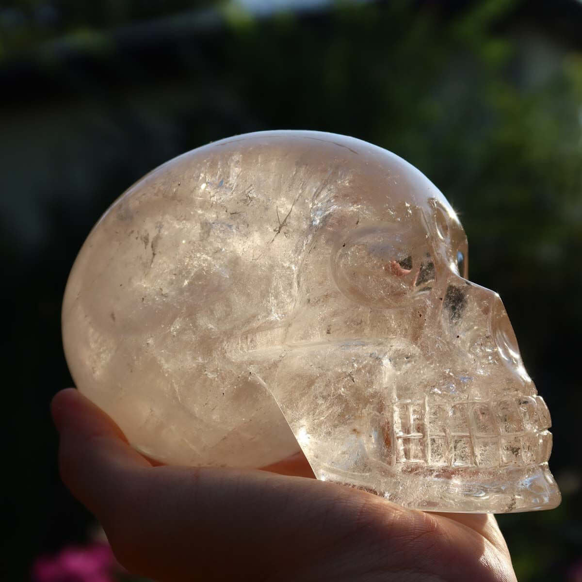 Hand holding handcrafted Citrine crystal skull, unique gemstone carving for collectors, available at Steinwelten.