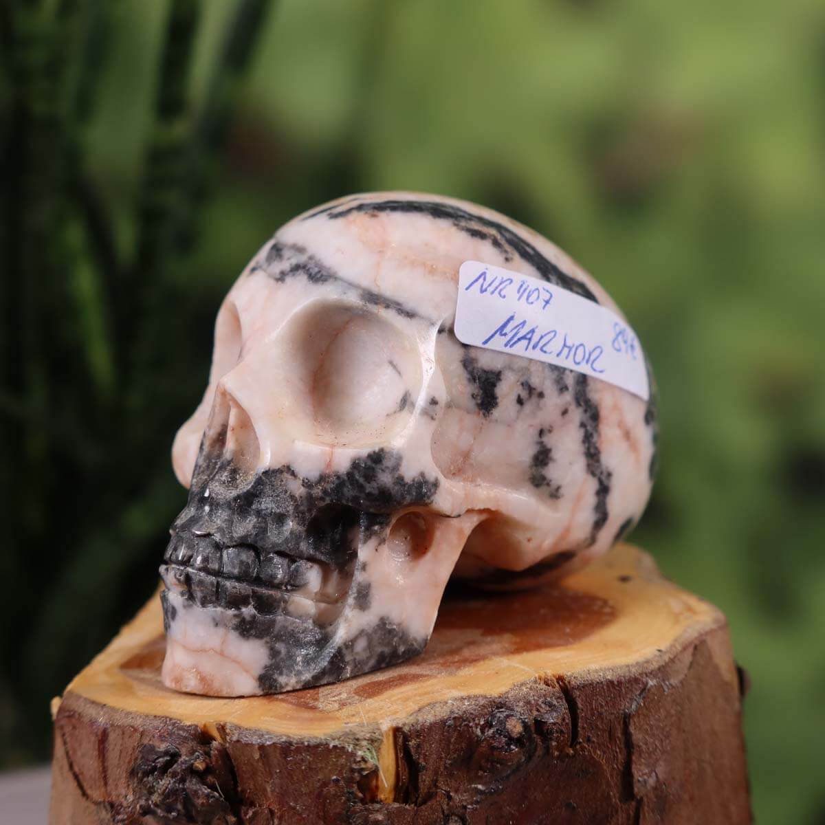 Handcrafted marble crystal skull with unique patterns, measuring 7x5 cm, displayed on a wooden surface.