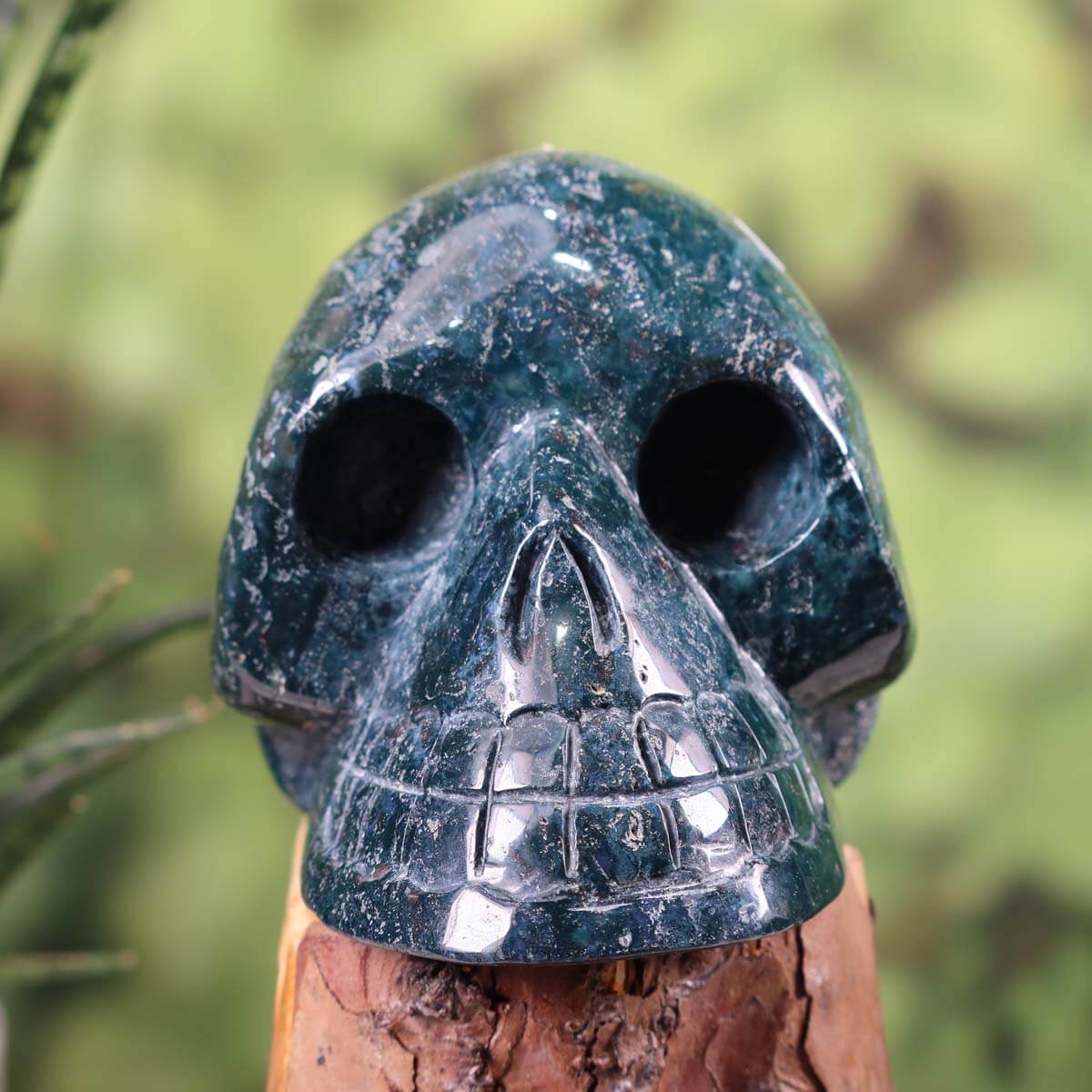 Handcrafted moss agate crystal skull, unique collectible piece, 13x10 cm. Buy minerals and gemstones online at Steinwelten.