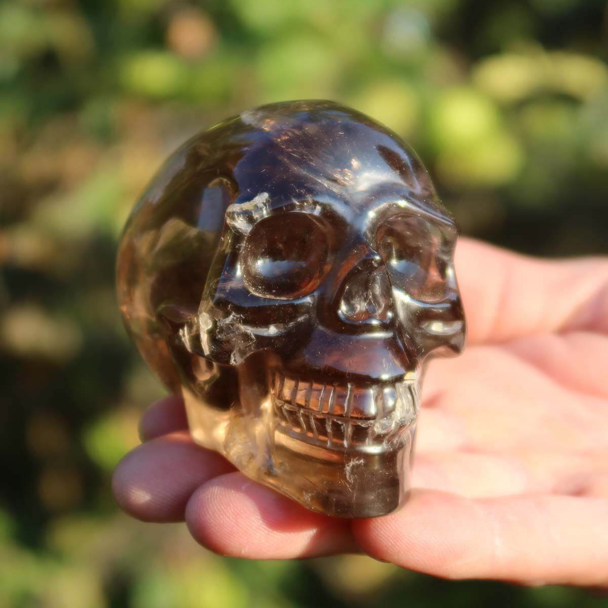 Handcrafted Rauchquarz crystal skull, unique Totenkopf Natur Stein from Steinwelten, 9x7 cm, sparkling in sunlight.