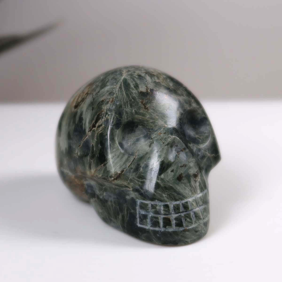Handcrafted Seraphinite Klinochlor crystal skull, unique collectible gemstone sculpture.