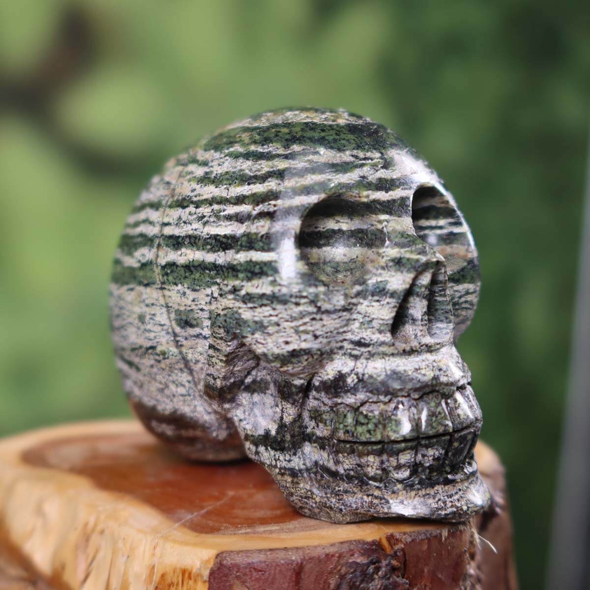 Handcrafted Serpentin Silberauge crystal skull on wooden base, 7x7 cm, unique design and color, product number 365