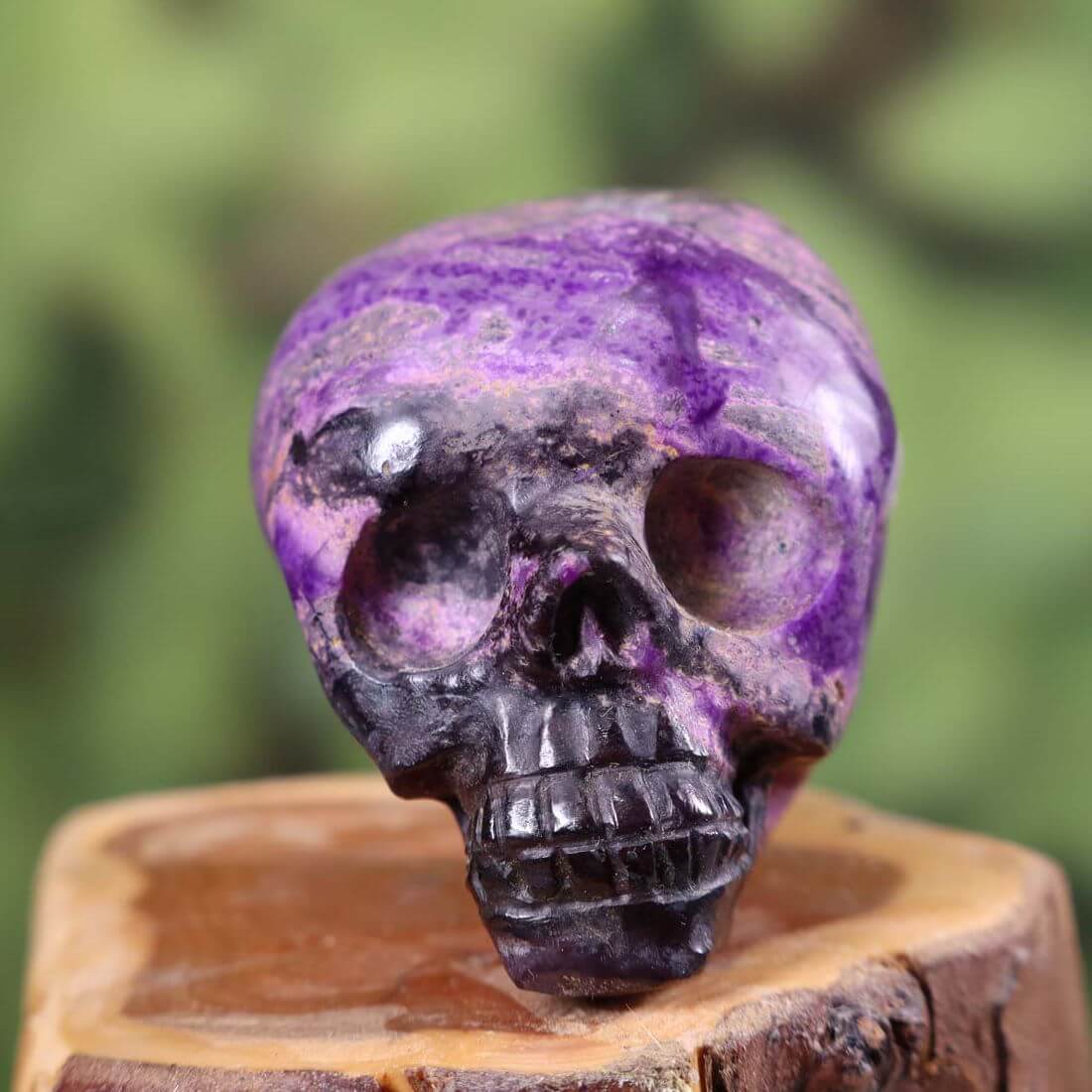 Handcrafted Sugilite crystal skull collector's item, 6x5 cm, unique mineral artistry with vivid purple hues.