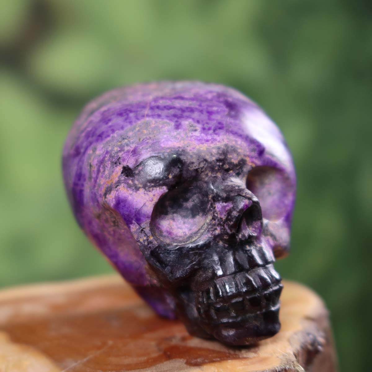 Handcrafted Sugilite crystal skull collector's item, 6x5 cm, unique mineral artistry with vivid purple hues.