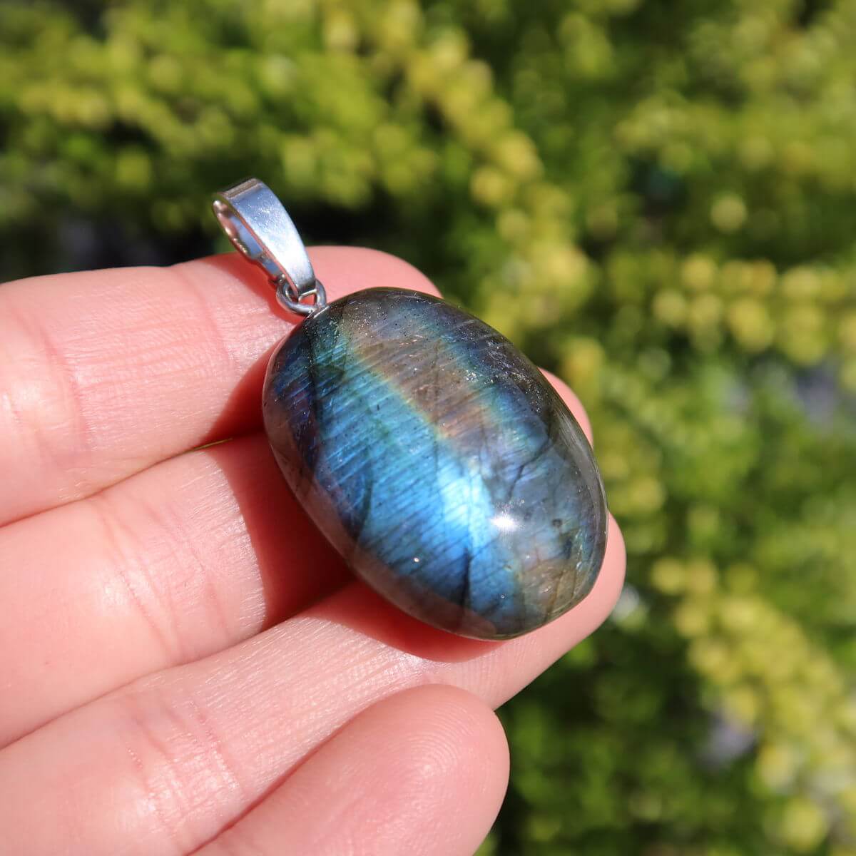 Natürlicher Labradorit Anhänger mit Silberschlaufe, schimmernd in Blau- und Grüntönen, erhältlich im Steinwelten Online Shop.