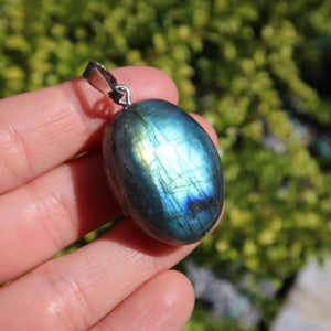 Natürlicher Labradorit Anhänger mit Silberschlaufe, zeigt blau-grüne Labradoreszenz, ideal für Heilstein Schmuck kaufen online.