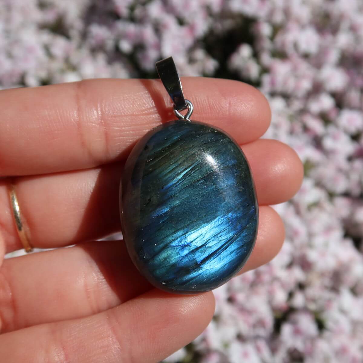 Natürlicher Labradorit Anhänger mit Silberschlaufe in Hand, einzigartiger Schimmer, Steinwelten Onlineshop Wiener Neustadt Graz