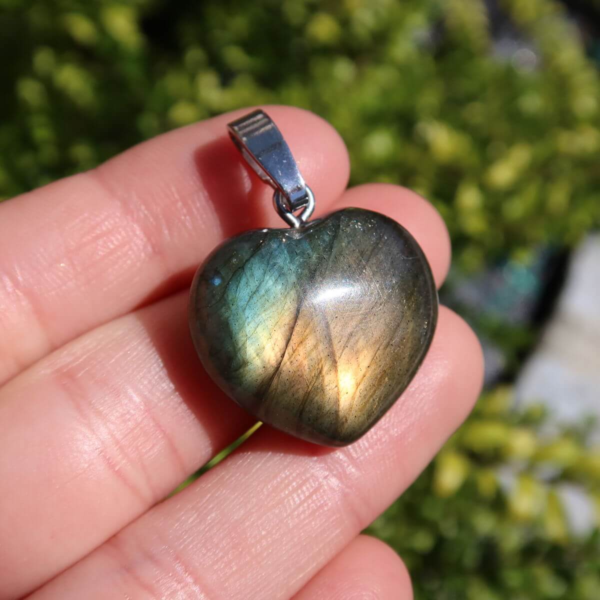 Labradorit Herz Anhänger 20mm mit leuchtenden Blau-, Grün- und Goldtönen in natürlichem Licht, einzigartiger Edelsteinschmuck.