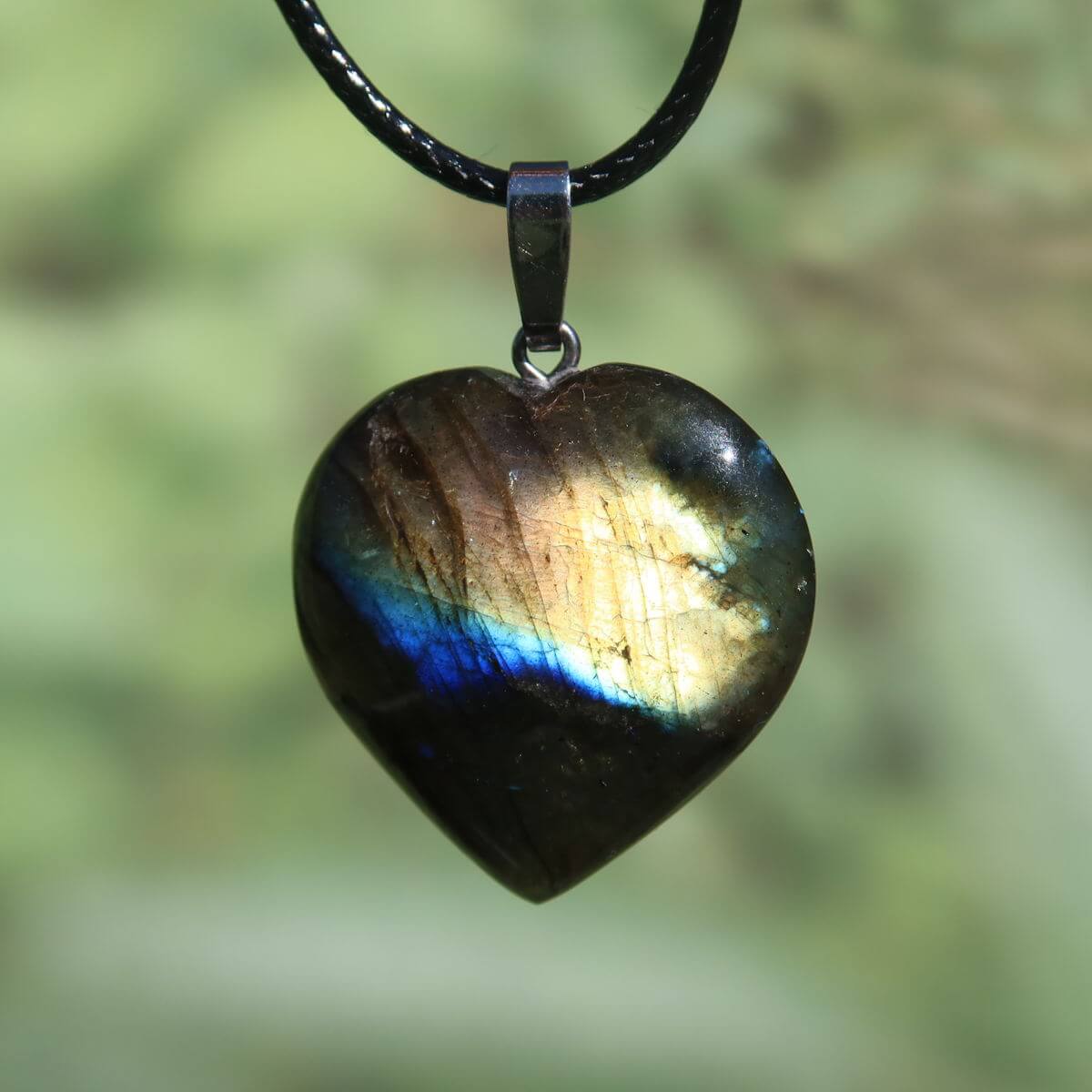Labradorite heart pendant showcasing vibrant blue, green, gold hues, 31mm, unique design emphasizing intuition and spirituality.