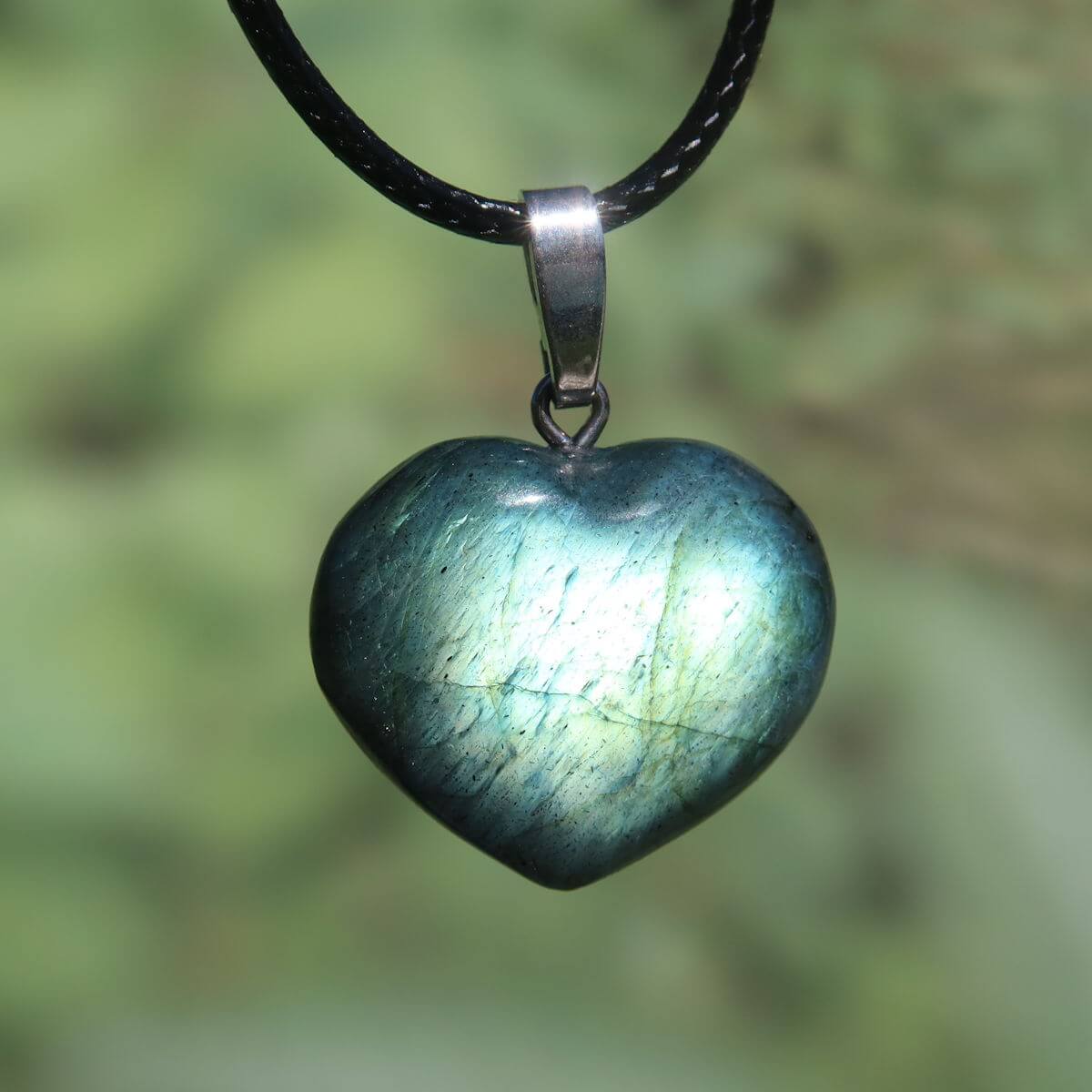 Heart-shaped Labradorite pendant with vibrant blue hues on a black cord, emphasizing intuition and spirituality.
