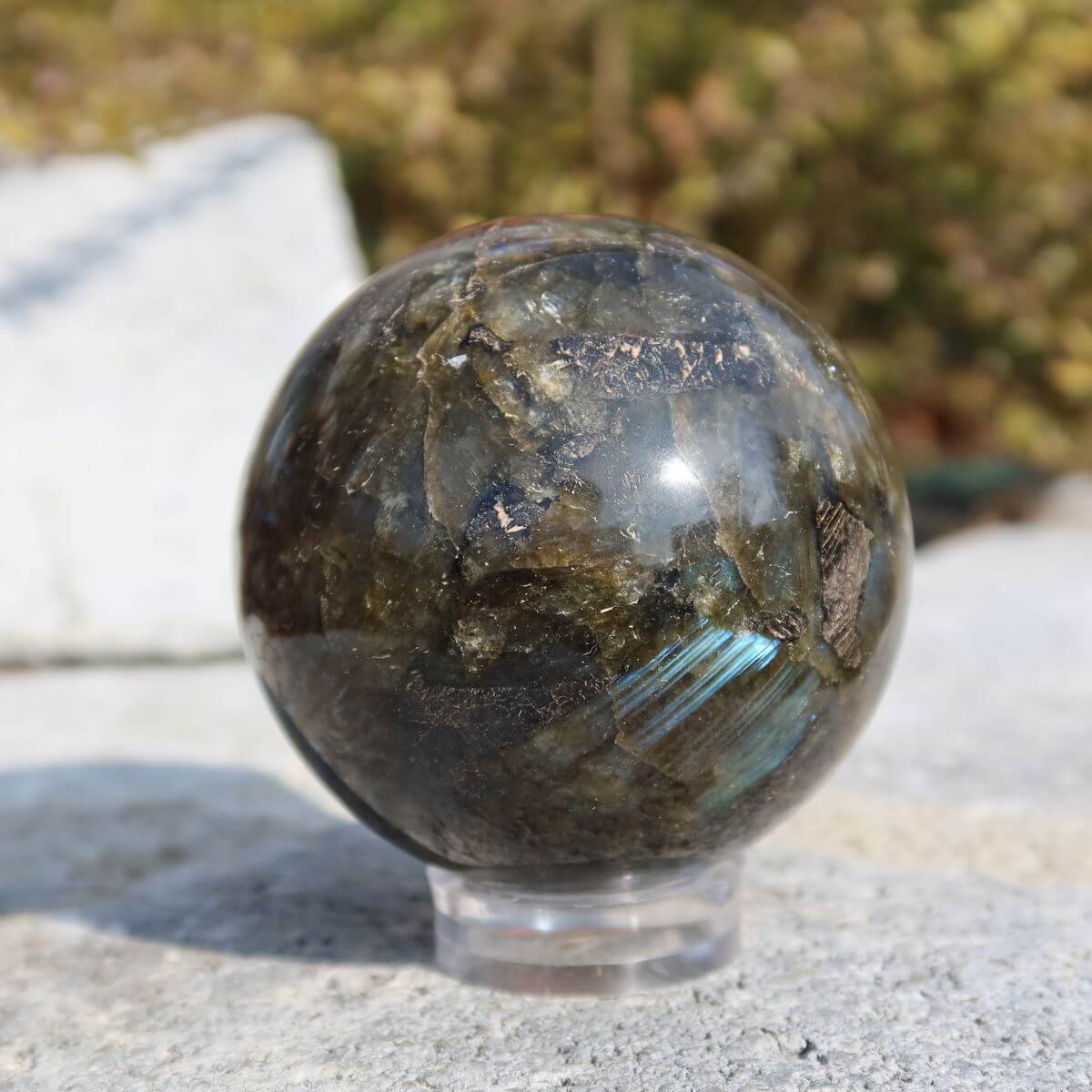 Glänzende Labradorit Kugel auf einem Ständer,  natürliche Farben und Muster, erhältlich bei Steinwelten. Jetzt online kaufen!