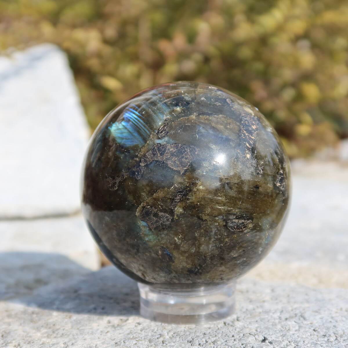 Glänzende Labradorit Kugel auf einem Ständer,  natürliche Farben und Muster, erhältlich bei Steinwelten. Jetzt online kaufen!