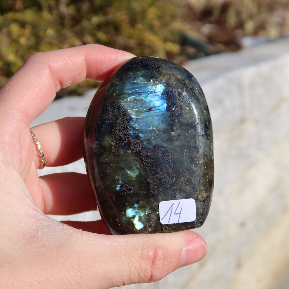 Labradorit Freiform poliert - 7x5cm - Intuition und Kreativität Nr.14 in der Hand gehalten, zeigt faszinierende Labradoreszenz.